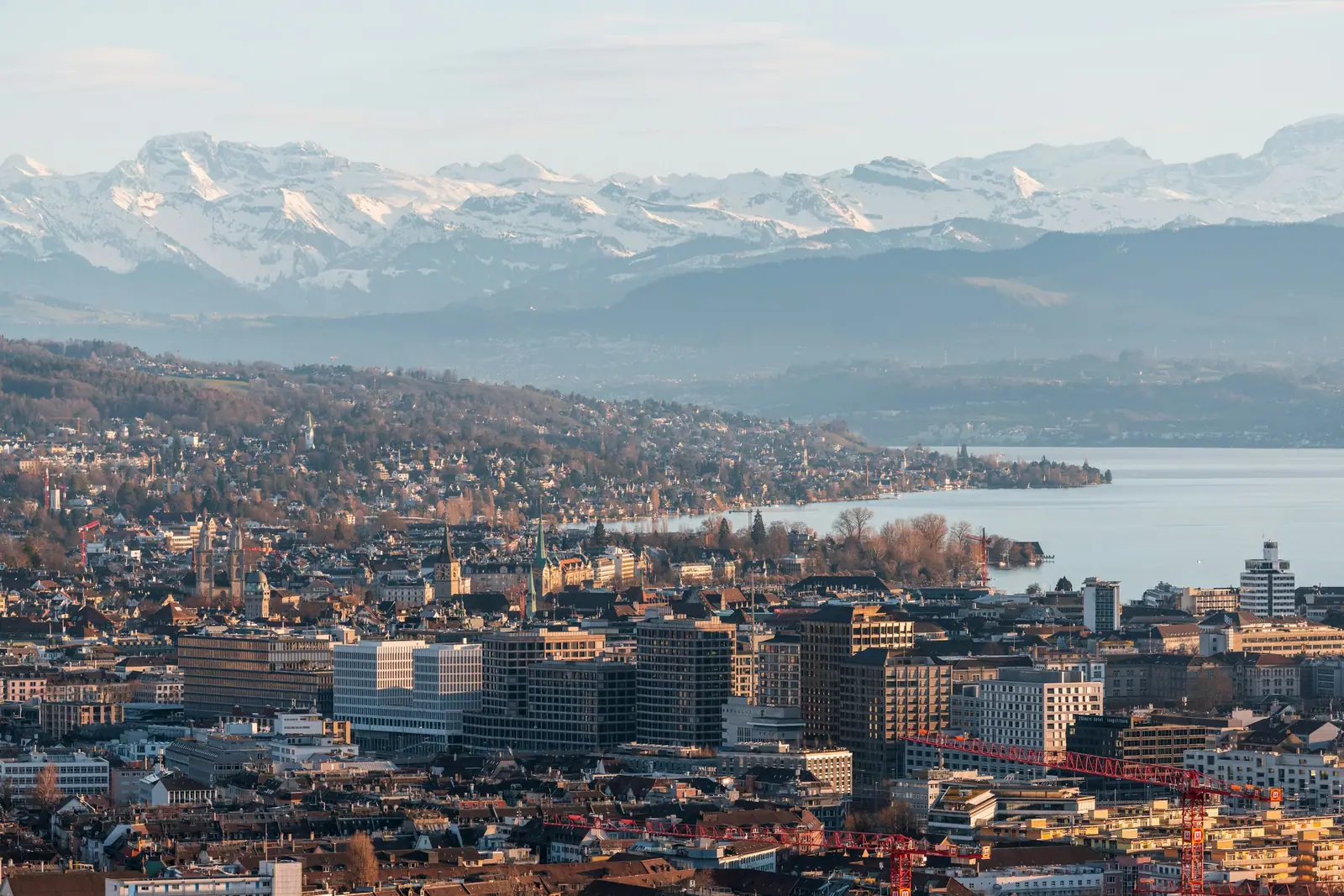 Blick über Zürich und den Zürichsee auf die verschneiten Alpen